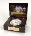 This wedge shaped table clock has a high gloss finish, a photo frame, white dial with Roman numerals, and a felt bottom. Photo opening is 3 x 4